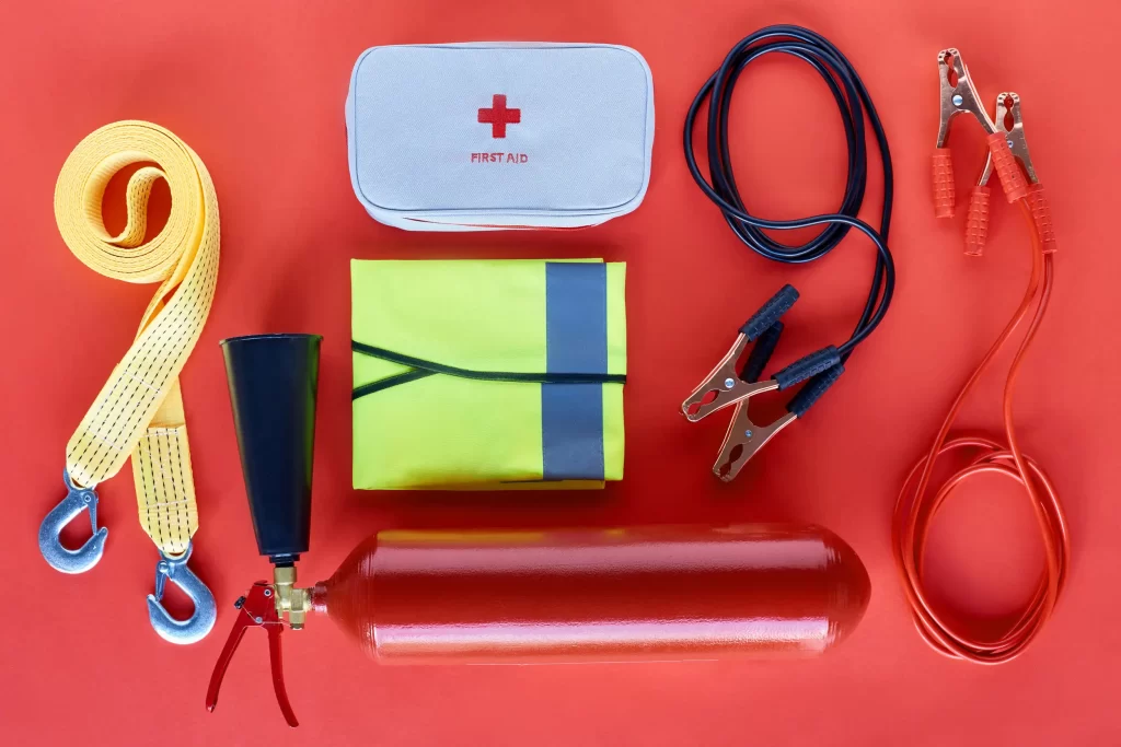 A well-stocked roadside emergency kit including fire extinguisher, jumper cables, and first aid supplies.