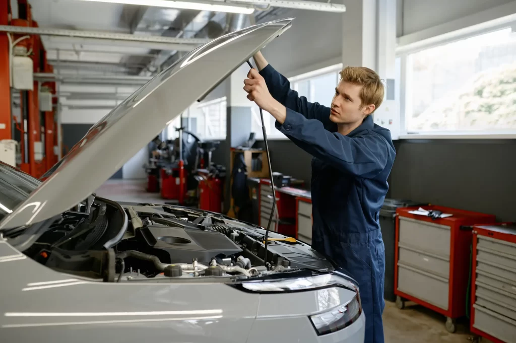 A mechanic about to perform a maintenance check on a car's fuel system.